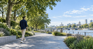 Man walking beside a river in bright daytime, illustrating natural light and regular movement for sleep health.